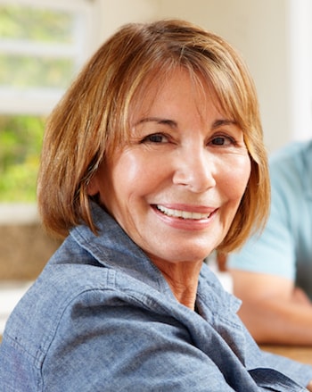 Smiling woman who needs a Dental Implants in Shelby Township denture