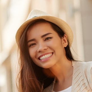 A girl wearing a hat and smiling due to General Dentistry in Shelby Township